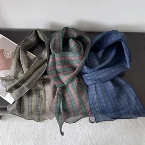 Primer plano detallado de bufandas de lino con patrones de cuadros verde, rojo y azul