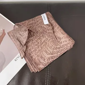 Detalle de bufanda de lino con líneas marrones abstractas sobre fondo cuero