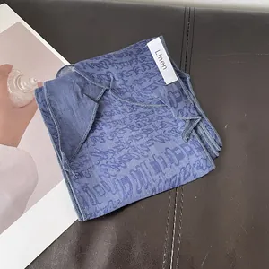 Primer plano de una bufanda de lino azul con estampado abstracto y costura fina