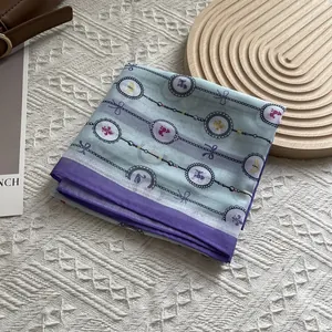 Detail eines hellblauen Blumenseidenschals mit transparenter Textur und Kettenmustern