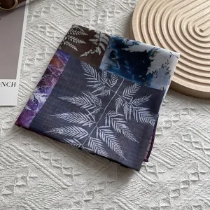 Detail of silk square scarf showing botanical fern print and patchwork color blocks