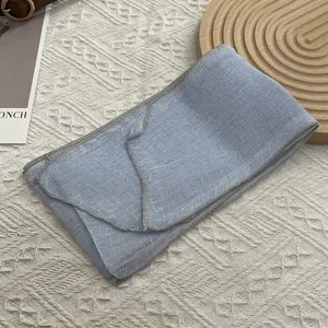 Λεπτομέρεια από γαλάζιο λινό κασκόλ με αναπνεύσιμη υφή πλέγματος και γκρι ραφή φινιρίσματος