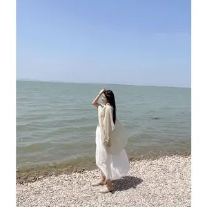 Détail d'un châle en lin beige avec bordures à franges sur la plage pour protection solaire