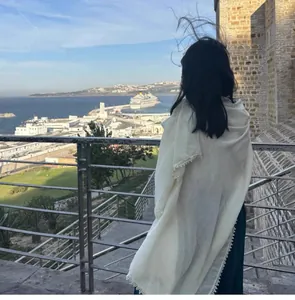 Détail d'un châle long blanc avec dentelle délicate dans un cadre de vacances en bord de mer