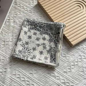Carré de soie respirant en coton et lin avec motif paisley sur support en bois