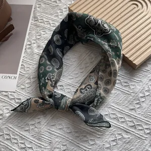 Detailed macro view of the vintage paisley print and fine texture of the square cotton scarf