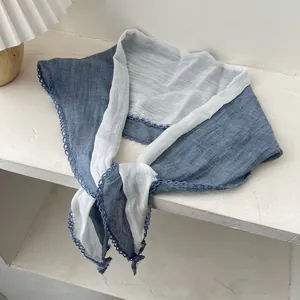 Détail d'une écharpe en coton et lin bleu et blanc avec élégante bordure en dentelle bleue