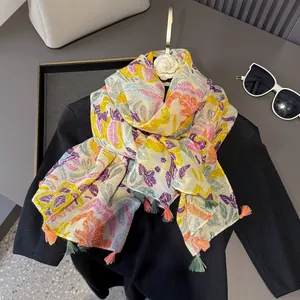 Détail d'une écharpe à imprimé plumes tropicales avec de longues franges décoratives élégantes