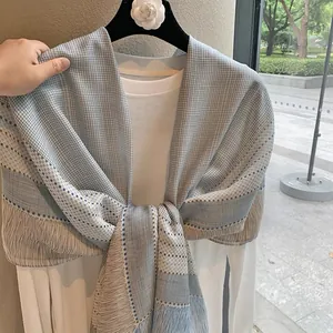 Vintage checkered linen shawl scarf with long tassels shown on a hanger with a white shirt