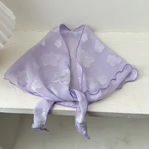 Detailaufnahme von hellviolettem transparentem Schal mit Blumenstickerei und Rüschenrand