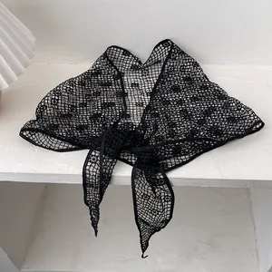 Detail of black crochet lace sunflower knit scarf with elegant hollow floral patterns