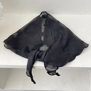 Detailansicht eines schwarzen transparenten Dreieckstuchs mit 3D-Blumenstruktur