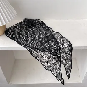 Detailed close-up of black lace hollow knit sunflower pattern and mesh texture