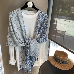 Écharpe bleue avec motifs de plumes, imprimés géométriques et pompons élégants
