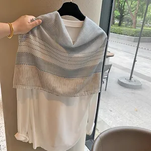 Detail of grey plaid and blue striped linen shawl with delicate fringe tassel edges