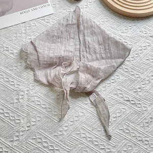 Détail d'un foulard en lin marron clair à carreaux avec texture de tissu et étiquette de lavage