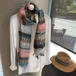 Detail of bohemian printed scarf with tassel fringe on a white minimalist shirt