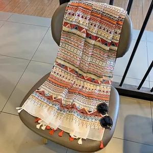 Detail of bohemian scarf with colorful geometric patterns and decorative tassels