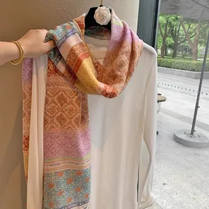 Close-up of lightweight colorful floral print scarf with elegant tassels and silk texture