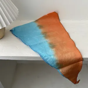 Λεπτομέρεια από βαμβακερό κασκόλ tie-dye σε μπλε και πορτοκαλί με λεπτή ραφή άκρης