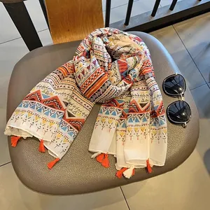 Detail of bohemian geometric scarf with vibrant color blocks and orange tassel fringe