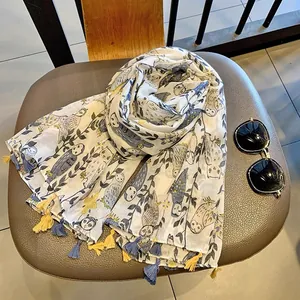 Detail of cute owl print scarf with colorful tassels on a stylish summer shawl