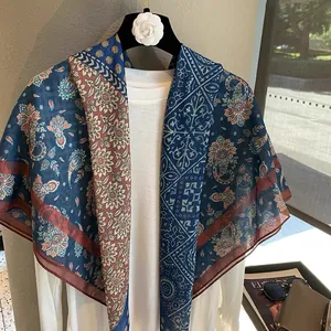 Damen Seidenschal mit blauem Paisleymuster, präsentiert mit modischen Accessoires und Magazin