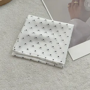 Elegant white polka dot sheer mesh square scarf displayed on a stylish fashion magazine