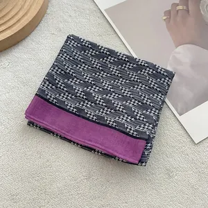 Foulard di seta a pied-de-poule con bordo viola su sfondo bianco con texture