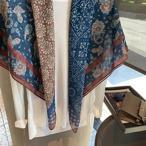 Detailansicht des leichten Paisley-Schals mit tiefblauen und roten Mustern auf Stoff