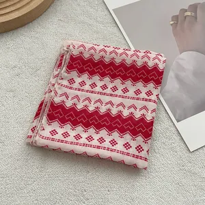 Detail of red and white cotton bandana featuring Nordic geometric heart patterns and hemmed edges
