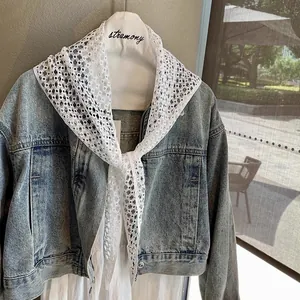 Detailed close-up of white cotton lace crochet pattern on a vintage style shawl scarf