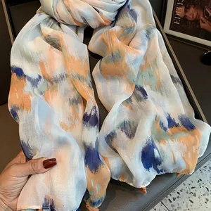 Detail of artistic ink print linen scarf with delicate fringe edges and soft drape