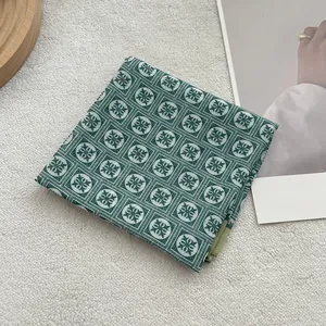 Floral cotton linen square scarf in dark green jacquard on a cozy minimalist background