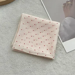 Detail of white silk square scarf with red polka dots and fine stitched edges