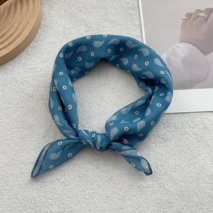 Close-up of knotted blue paisley print cotton linen scarf with silky texture detail