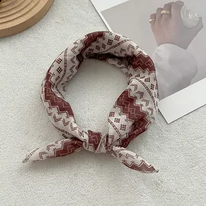 Close-up of bohemian brown geometric print cotton scarf tied in a stylish circular knot