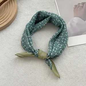 Detail of floral linen neckerchief with geometric patterns in olive green and dark tones
