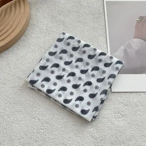 Detailed view of paisley printed cotton neck scarf on a minimalist lifestyle background
