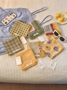 Flat lay of colorful cotton linen headscarves with floral patterns and summer accessories