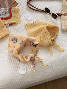 Detail of yellow cotton linen scarves with strawberry and polka dot patterns for summer
