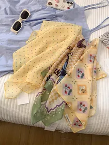 Detail of assorted summer silk scarves with polka dot and strawberry floral patterns