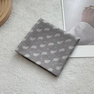 Detail of grey cotton linen paisley pattern neck scarf on elegant white background
