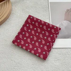 Detailed view of red paisley pattern and textile texture on cotton linen small square scarf