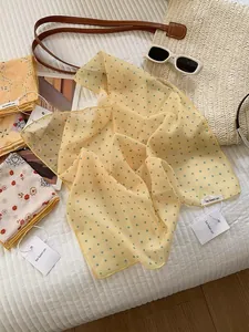 Close-up of lightweight chiffon scarves with polka dots and floral patterns for summer