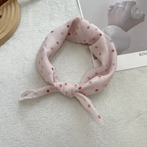 Detailed shot of pink polka dot silk scarf with semi-transparent texture on textured background