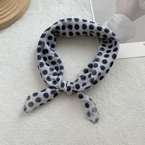 Detail of gray linen neck scarf with black polka dots and smooth hemmed edges