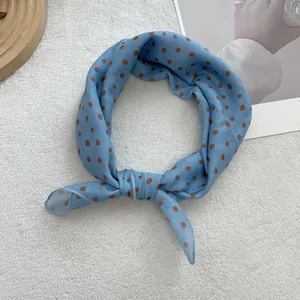 Detail of soft light blue polka dot cotton-linen neck scarf with brown pattern