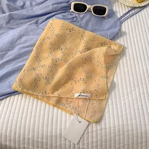 Close-up of yellow floral cotton linen scarf with be keen on label and white tag