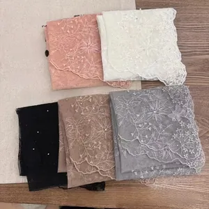 Detail of five colors lace scarves with floral embroidery and hand-sewn pearl accents
